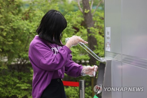 23일 오전 서울 관악구 서울대학교 자연과학대학에서 서울대 관계자가 신종 코로나바이러스 감염증(코로나19) 신속 분자진단 검사를 받은 뒤 검체 보관함에 검체키트를 넣고 있다. 이번 주까지 시범운영을 마친 뒤 오는 26일부터 학내 일부 구성원들을 대상으로 검사가 진행될 예정이며, 검사 결과는 1인당 약 1시간이 소요되는 것으로 전해졌다. /연합뉴스