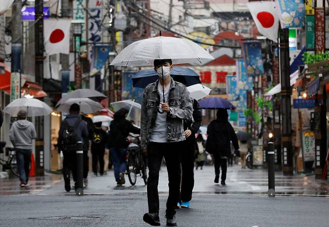 코로나19로 인한 긴급사태가 발효 중인 도쿄 시내에서 5일 마스크를 쓴 남성이 쇼핑가를 걷고 있다. 도쿄|로이터연합뉴스