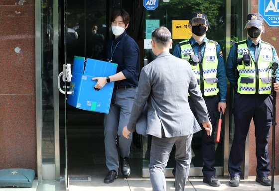 경찰 관계자들이 지난 6일 오후 박상학 자유북한운동연합 대표의 사무실에 대한 압수수색을 마친 뒤 압수품을 들고 나오고 있다. 연합뉴스