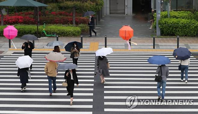 지난 4일 서울시 중구 세종로에서 직장인들이 우산을 쓰고 출근하고 있다. [연합뉴스 자료사진. 재판매 및 DB 금지]