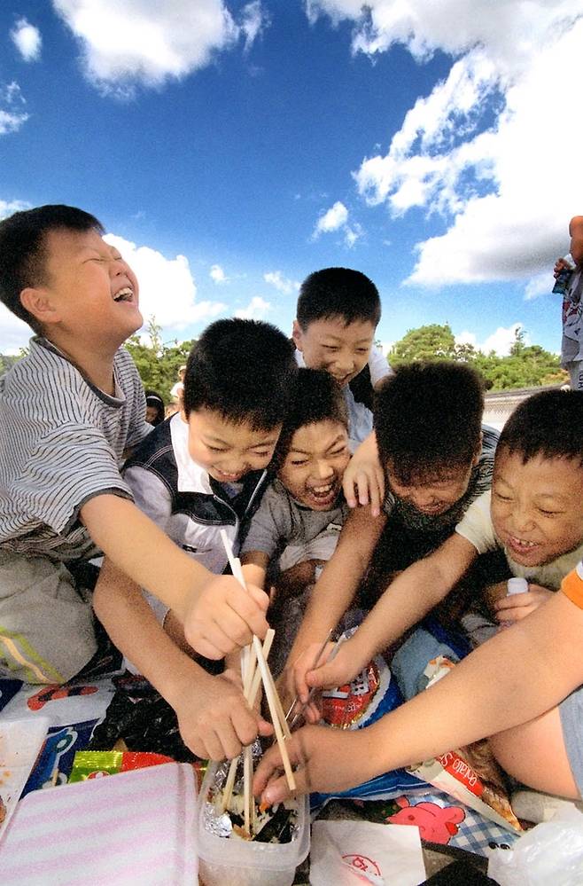 광화문 일대 견학에 나선 초등학교 학생들이 자기 몫의 도시락이 부족한 지 옆 친구의 김밥을 먹으려 달려들고 있다. 학창 시절 학교에서 흔한 풍경이었다. 2001년 [연합뉴스 자료사진]
