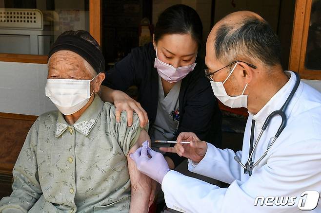21일(현지시간) 일본 나가노현 기타아이키에서 의료 종사자가 가정을 방문해 노인에게 코로나19 화이자 백신을 접종하고 있다. © AFP=뉴스1 © News1 우동명 기자
