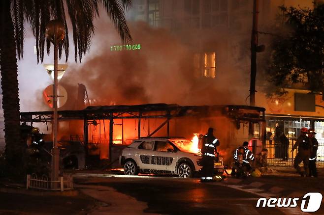 팔레스타인 무장정파 하마스가 가자지구에서 발사한 로켓 공격에 이스라엘에서 버스 등 차량이 불타고 있다. © 로이터=뉴스1