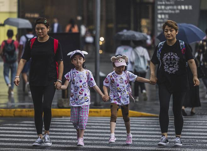 중국 인구가 10년 전 13억3972만여명에서 14억1178만명으로 늘었지만, 우리 동포가 주로 거주하던 동북 3성 지방 인구는 1100만명이나 급감한 것으로 조사됐다. 사진은 중국 상하이에서 횡단보도를 건너고 있는 중국인 가족.[EPA]