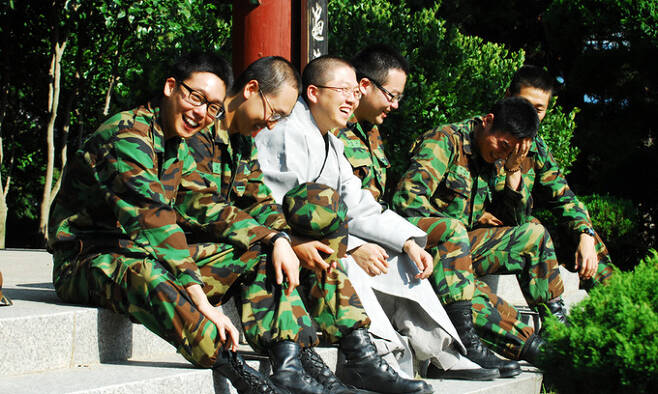 군법사 지용 스님(왼쪽에서 세 번째)이 불자 병사들과 환담 중에 함박웃음을 짓고 있다.