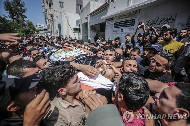이스라엘군 공습 사망자 장례식 치르는 팔레스타인인들 (가자 EPA=연합뉴스) 팔레스타인 자치 지역인 가자지구에서 11일(현지시간) 주민들이 이스라엘군의 공습으로 숨진 지하드(이슬람 성전) 전사의 장례식을 치르기 위해 시신을 운구하고 있다. 이스라엘군과 팔레스타인 무장 정파 하마스는 이틀째 화력전을 벌여 양측에서 모두 31명의 사망자가 발생했다. sungok@yna.co.kr