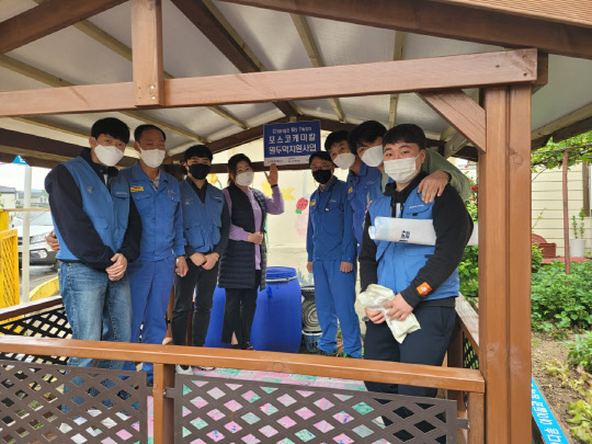 포스코케미칼 마그네시아 공장직원들과 지역아동센터장이 직접 지은 원두막에서 기념사진을 촬영하고 있다. <포스코케미칼 제공>