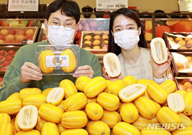 [서울=뉴시스]21일 서울 중구  롯데마트 서울역점에서 롯데마트 이승훈 과일MD(상품기획자, 왼쪽)와 모델이 '올해 첫 출하된 성주 참외'를 홍보하고 있다. 2021.01.21. (사진=롯데마트 제공) photo@newsis.com