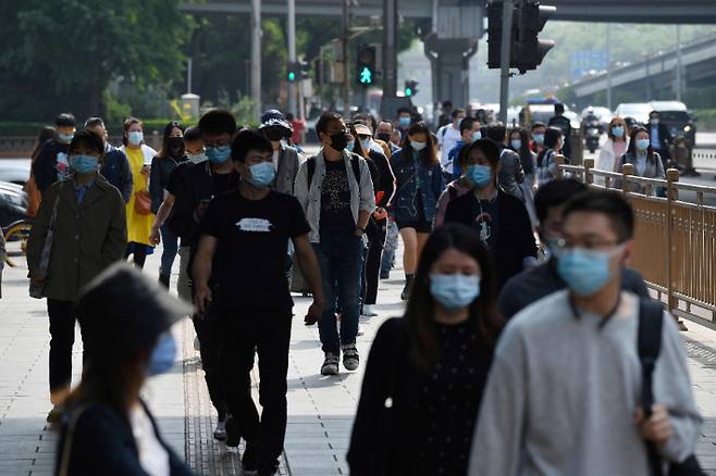 11일 중국 베이징에서 마스크를 쓴 시민들이 아침 러시아워 대에 출근길을 서두르고 있다. 연합뉴스