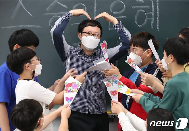 스승의 날을 앞둔 지난 13일 대전 한 초등학교에서 담임교사가 학생들이 직접 그린 카네이션과 손편지를 받고 있다. 2021.5.13/뉴스1 © News1 김기태 기자