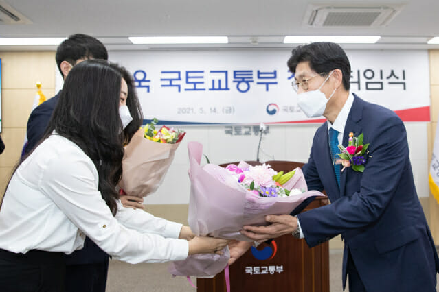 노형욱 국토교통부 장관(오른쪽)이 14일 취임식을 마치고 직원으로부터 축하 꽃다발을 받고 있다.