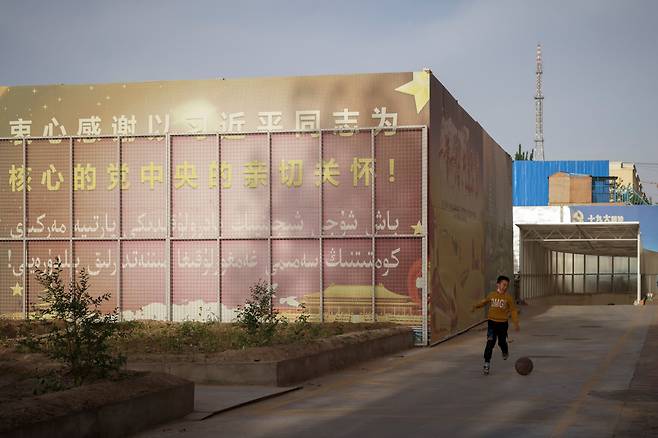 지난달 28일 중국 신장위구르자치주 처러에 있는 쟈먼 이슬람 사원 앞에 공산당 선전 문구가 적힌 대형 장벽이 설치돼 있다. "당과 시진핑 동지의 사랑스러운 배려에 가슴깊이 감사하자"는 내용이다. /로이터 연합뉴스