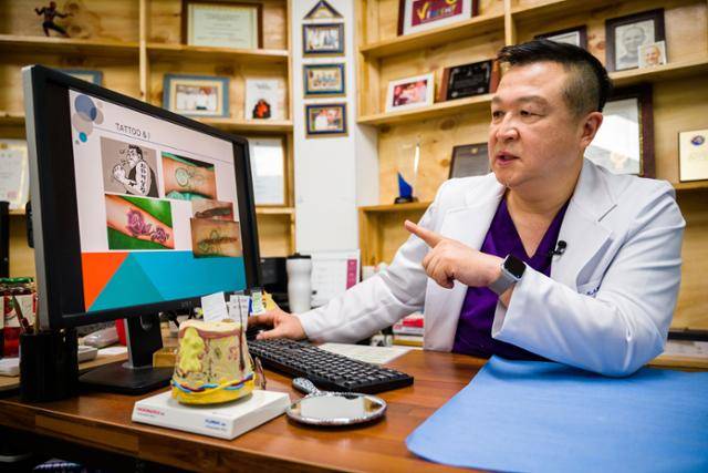 그가 자신이 지웠거나 시술한 타투 사진을 보며 설명하고 있다. 한진탁 인턴기자