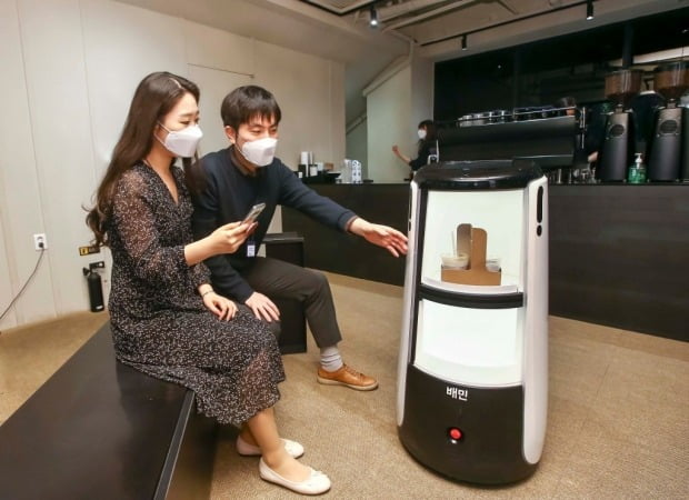서울 광화문 D타워에서 배달로봇 딜리타워가 커피를 배달하는 모습. [사진=우아한형제들 제공]