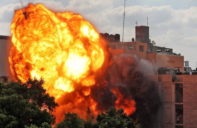 13일(현지시간) 이스라엘군의 공습을 맞은 팔레스타인 가자지구 한 건물에서 화염이 치솟고 있다. 연합뉴스