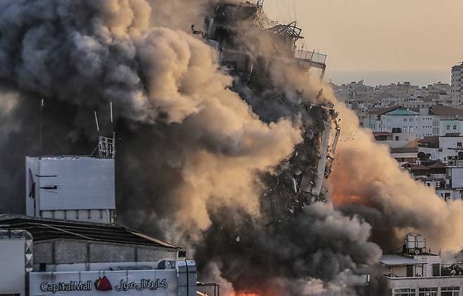 팔레스타인 자치 지역인 가자지구의 중심도시 가자시티에서 지난 12일(현지시간) 이스라엘군의 공습으로 알쇼루크 타워가 연기와 화염에 휩싸인 채 무너지고 있다. 연합뉴스