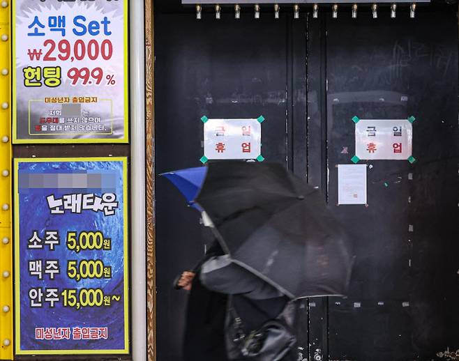 신종 코로나바이러스 감염증(코로나19) 확산 억제를 위해 수도권과 부산 지역 유흥시설의 영업 금지 첫날인 지난 4월 12일 밤 서울 종로구의 한 감성주점 출입문에 집합금지 명령서와 휴업 안내문이 붙어 있다. (사진= 연합뉴스)