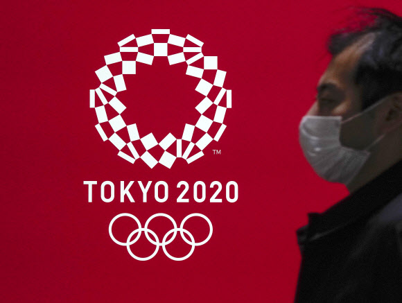 - 도쿄에서 한 시민이 마스크를 쓴 채 도쿄올림픽 엠블럼 디자인 앞을 지나가고 있다.도쿄 EPA 연합뉴스