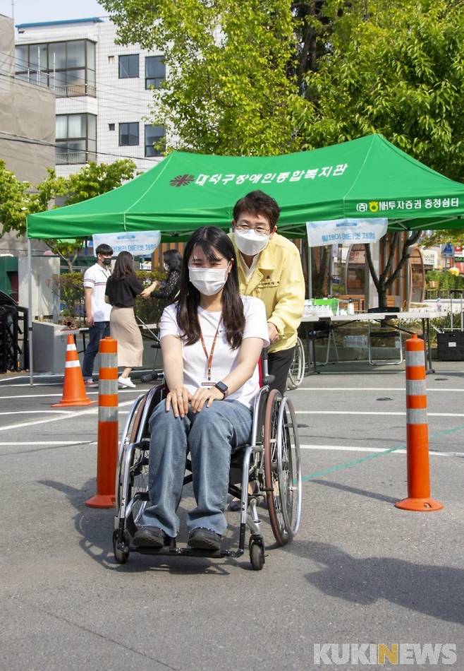 박정현 대덕구청장이 휠체어를 밀며 장애체험행사를 하는 모습.