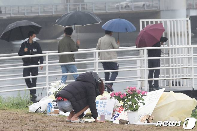 17일 오전 서울 서초구 반포한강공원 수상택시 승강장 인근에서 한 시민이 故 손정민씨를 추모하고 있다. 경찰은 이날 정민씨의 친구 A씨의 스마트폰 수색 작업을 진행했다. 2021.5.17/뉴스1 © News1 임세영 기자