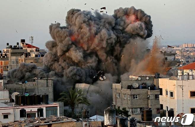 16일(현지시간) 팔레스타인 가자지구 가자시티의 주거지역 내 건물에서 이스라엘군의 폭격으로 화염과 거대한 먼지가 치솟고 있다. © AFP=뉴스1 © News1 우동명 기자