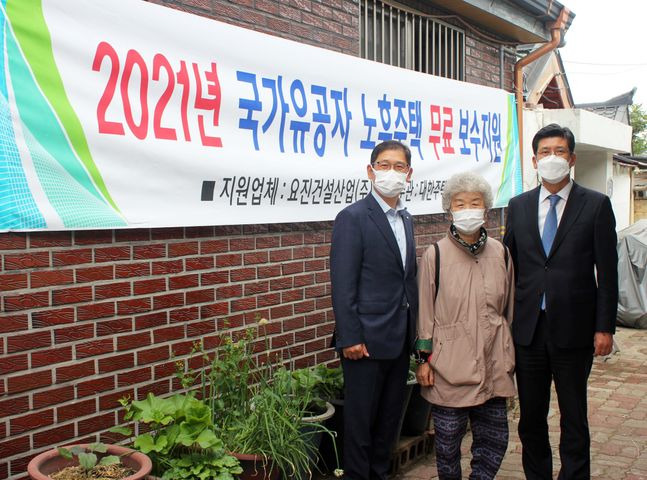 이병호 요진건설산업 상무(오른쪽)와 윤진오 대한주택건설협회 강원도회 사무처장이 강원도 원주시 태장동 소재 전상군경 유족 이일염(79)씨 주택을 방문해 기념사진을 촬영하고 있다.ⓒ요진건설산업