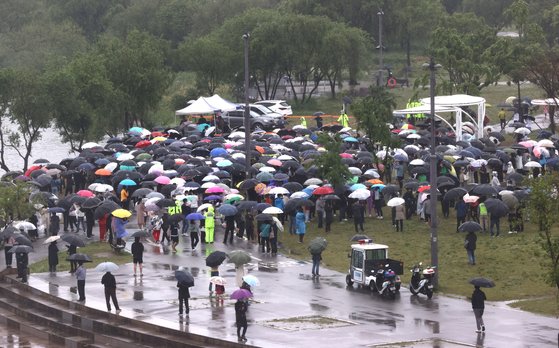 '16일 오후 서울 반포한강공원 수상택시 승강장 인근에서 열린 '고 손정민 군을 위한 평화집회'에서 참가자들이 우산을 쓴 채 자리를 지키고 있다 연합뉴스