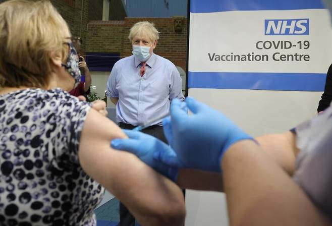 영국 런던에서 보리스 존슨 총리가 한 시민이 화이자의 코로나19 백신을 맞는 모습을 보고 있다. 신화/연합뉴스 제공