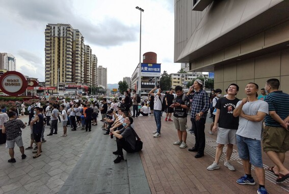 중국 광둥성 선전 중심가에 있는 ‘SEG 플라자’ 건물이 18일 갑자기 흔들리자, 사람들이 보고 있다. 선전/AFP 연합뉴스