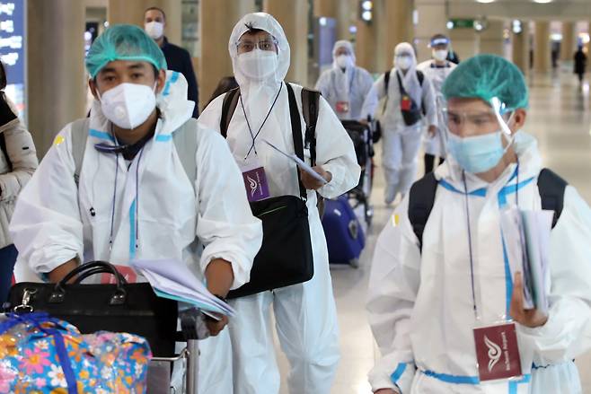 지난 5일 영종도 인천국제공항에서 방역복을 입은 해외 입국자들이 임시 격리시설로 향하고 있다. /연합뉴스