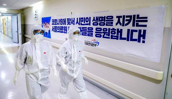 지난해 3월 코로나19 확진 판정을 받고 서울의료원으로 이송돼 치료중인 중증장애인 5명을 돌보는 간호사들이 16일 레벨D 방호복을 입고 음압병상으로 올라 가고 있다. 이석우 기자