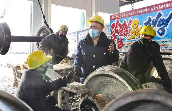 북한 노동당 기관지 노동신문에 실린 평양조차장객화차대. 근로자들 뒤로 '당 결정은 우리 생명'이라는 구호가 적혀 있다. 안전모 이외의 별다른 안전도구를 갖추지 않은 근로자들이 무거운 바퀴 등을 맨손과 맨몸에 의지해 수리, 정비하고 있다. 뉴스1