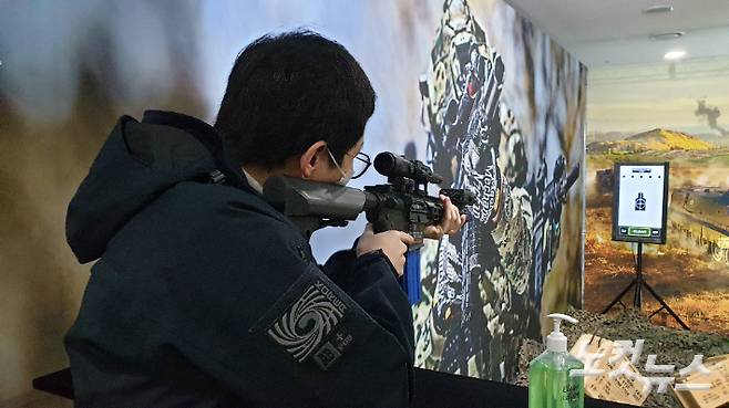 지난해 11월 육군 주최로 열린 '워리어 플랫폼 국회 포럼'에서 CBS노컷뉴스 취재진이 워리어 플랫폼 조준경이 장착된 에어소프트건을 체험해 보고 있다. 해당 에어소프트건은 배터리를 이용해 일정 수준의 반동이 구현돼 있다.