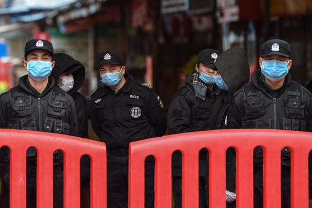 지난해 1월 중국 우한 화난 수산시장 입구를 중국 공안과 경비원들이 지키고 있다. 우한=AFP 자료사진