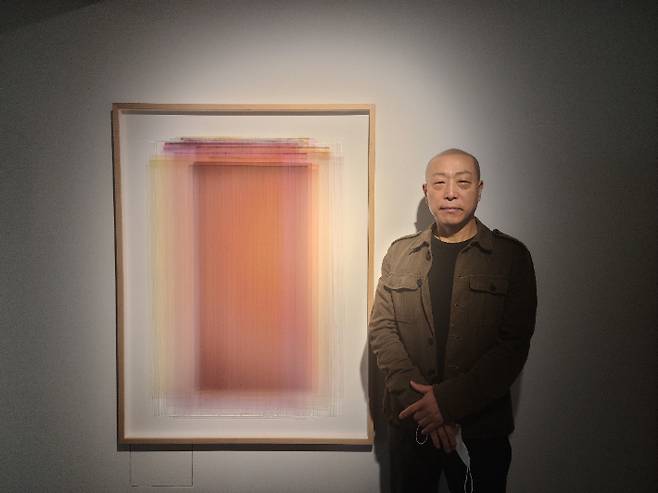 장승택 작가가 자신의 '겹 회화' 작품 앞에서 포즈를 취하고 있다.  곽인숙 기자