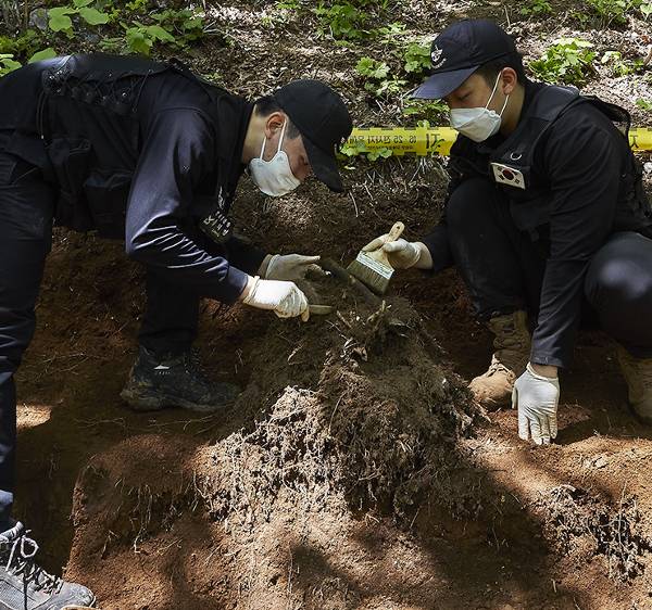 국방부 유해발굴감식단 송치영 하사(왼쪽)와 이성민 상병이 지난달 말 강원도 화천 취봉 남쪽 887고지에서 6·25전쟁 전사자 유해를 정성스레 수습하고 있다.