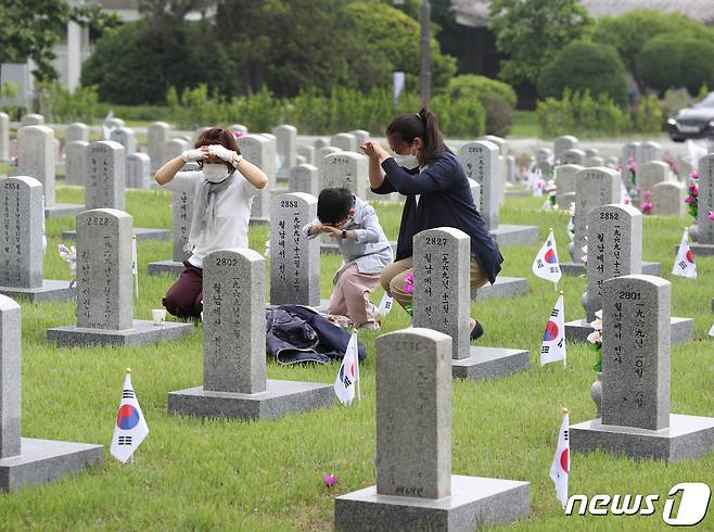 제66회 현충일을 하루 앞둔 5일 오전 서울 동작구 국립서울현충원을 찾은 참배객들이 절을 하고 있다. 2021.6.5/뉴스1 © News1 신웅수 기자