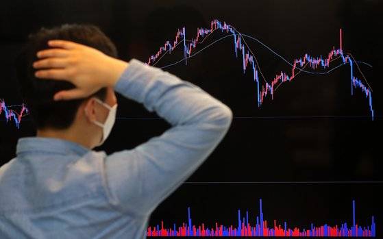 지난달 17일 오후 서울 강남구 빗썸 강남센터 라운지에서 관계자가 비트코인을 비롯한 암호화폐 시세를 살펴보며 머리를 긁적이고 있다. 뉴스1