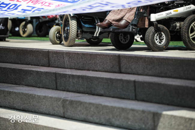 지난 4월 19일 서울 중구 국가인권위원회 앞서 열린 ‘장애인 참정권 차별 진정서 제출 기자회견’에서 휠체어를 탄 시민들이 지나치게 가파른 경사로를 피해 인도를 빙 돌고 있다.| 경향신문 자료사진