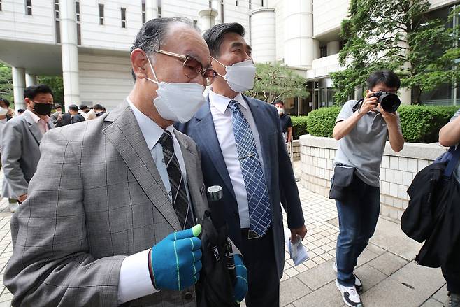 Lim Cheol-ho (left), whose father died in Japan during the war as a victim of forced labor, leaves the court after the judge dismisses the lawsuit filed by 85 plaintiffs on Monday. (Yonhap)