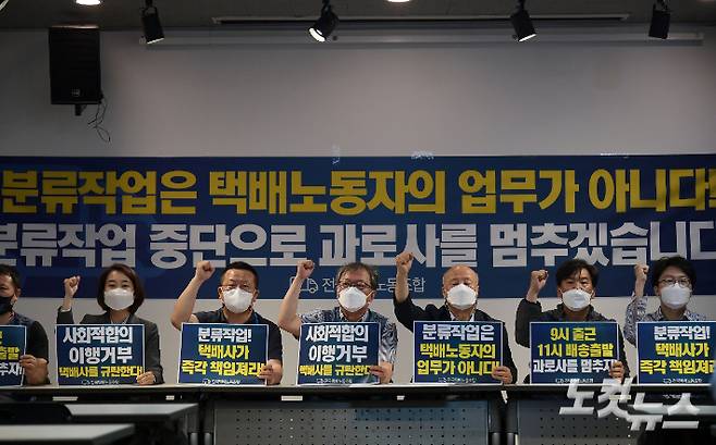 지난 4일 서울 종로구 참여연대에서 열린 '택배노동자 과로사 방지를 위한 사회적 합의기구 최종합의를 앞둔 택배노조 기자회견'에서 전국택배노동조합 관계자들이 손 피켓을 들고 있는 모습. 이한형 기자