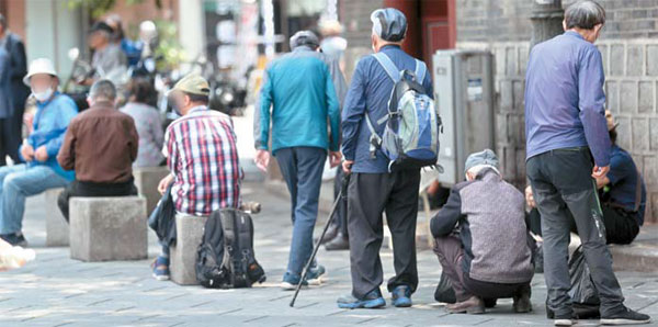 8일 서울 종로구 탑골공원에서 노인들이 무료급식소 앞에 줄을 길게 서 있다.  [이충우 기자]