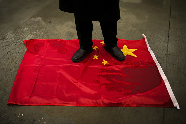 터키에 거주하는 위구르 공동체의 한 관계자가 지난 3월 왕이 중국 외교부장의 터키 방문에 맞춰 이스탄불에서 열린 위구르 인권 탄압 규탄집회 도중 중국 국기인 오성홍기를 밟고 서 있다.  AP 뉴시스