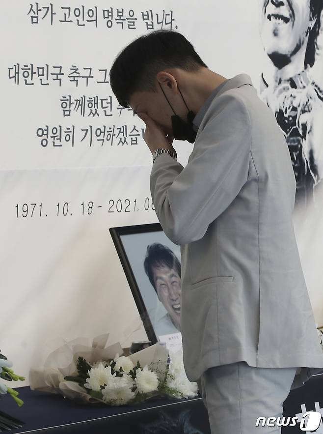 9일 울산 문수축구경기장에 고(故) 유상철 전 감독을 애도하기 위한 추모 공간이 마련된 가운데 유상철 감독의 팬인 홍지수씨가 고인의 사진 앞에서 눈물을 흘리고 있다. 2021.6.9 /뉴스1 © News1 윤일지 기자