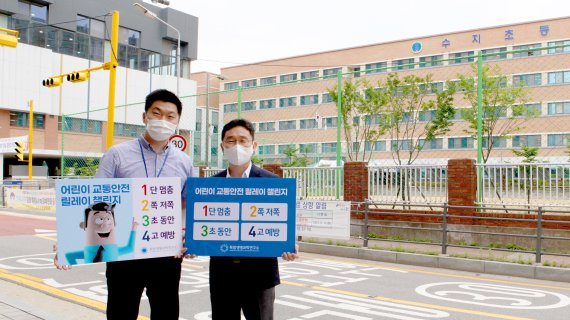 정재욱 목암생명과학연구소장(오른쪽)과 김동식 팀장이 경기도 용인시 정평로 수지초등학교 앞에서 어린이 교통안전 릴레이 챌린지를 진행했다.