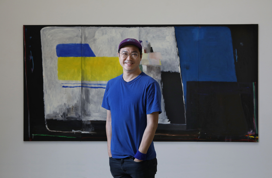 Bek Hyun-jin poses for a photo after an interview with the Korea JoongAng Daily in front of his work "Bright Darkness" (2020) at PKM Gallery in central Seoul Wednesday. [PARK SANG-MOON]