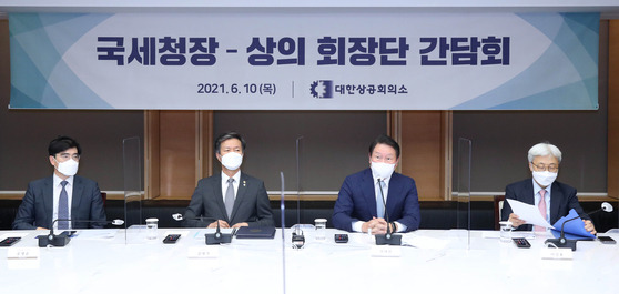 National Tax Service Commissioner Kim Dai-ji, second from left, and KCCI Chairman Chey Tae-won attend a meeting at the KCCI offices in central Seoul on Thursday. [KCCI]