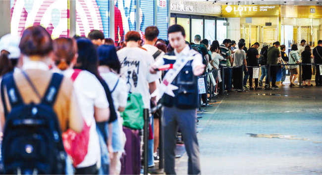 서울 중구 롯데면세점 본점 입구에서 중국인 관광객들이 면세점 개점을 기다리며 길게 줄 서 있다. [뉴스1]