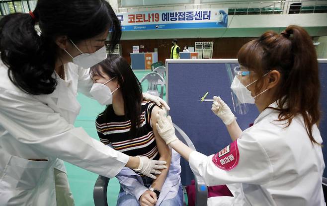 광주 북구 코로나19 예방접종센터에서 15일 의료진이 만 30세 미만 사회 필수인력 접종 대상자에게 화이자 백신을 접종하고 있다.   연합뉴스