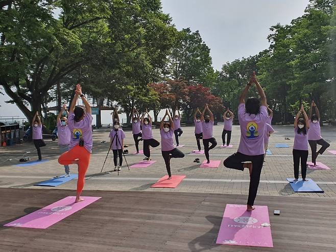 Indian Ambassador to Korea Sripriya Ranganathan and Embassy staff members practice yoga in front of Namsan Seoul Tower on Monday ahead of International Yoga Day. (Embassy of India in Seoul)